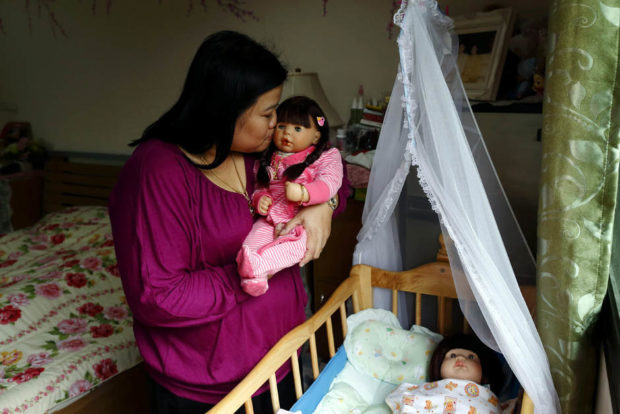 epa05124212 A picture made available on 25 January 2016 shows Thai devotee Ratchada Mahanavanont, 45, cradling her Child Angels Dolls at her house in Bangkok, Thailand, 24 January 2016. The new superstitious trend among Thai people involves carrying, talking and caring for factory-manufactured dolls (called 'Look Thep' in Thai). They believe the dolls hold children's spirits which bring good luck, wealth, blessing and protection from harm. Child Angels dolls owners worship and treat them as human infants by cradling, feeding and dressing up them up. Dolls cost from 2,000 Thai baht (55.65 US dollar or 51.47 euro) to 20,000 Thai baht (556.5 US dollar or 514.84 euro). The trend has even prompted Thai Smile Air to allow passengers to buy tickets for their Child Angels dolls, agreeing to serve them onboard drinks and food and several restaurants in Bangkok have announced they will serve children's meals to the dolls. EPA/RUNGROJ YONGRIT